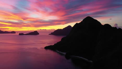 Aerial-view-of-dramatic-karst-scenery-and-turquoise-ocean-water-during-amazing-red-sunset-in-El-Nido,-Palawan,-Philippines