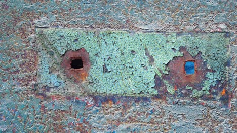 placa metálica oxidada con agujeros y pintura agrietada