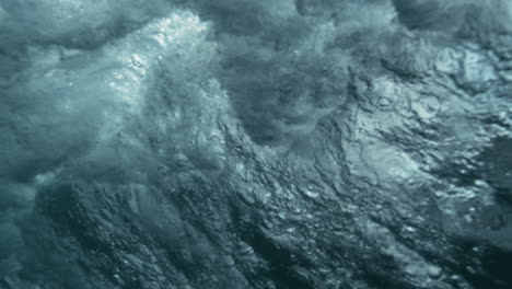 slow motion underwater wave glimmers in scattered light, fluid textures and quiet movement
