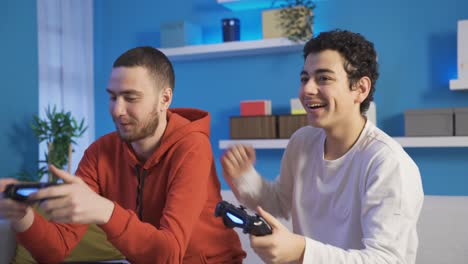 brothers playing games with console resting on sofa in living room.