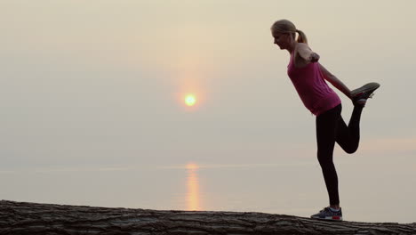 Active-Middle-Aged-Woman-Doing-Stretching-And-Balance-Exercise-In-A-Picturesque-Place-By-The-Sea