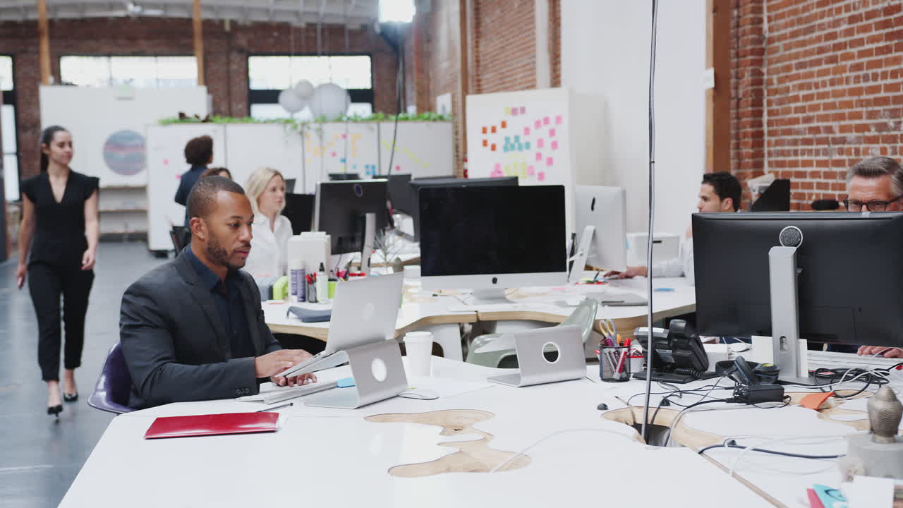 Business Team Working At Desks In Modern Open Plan Office