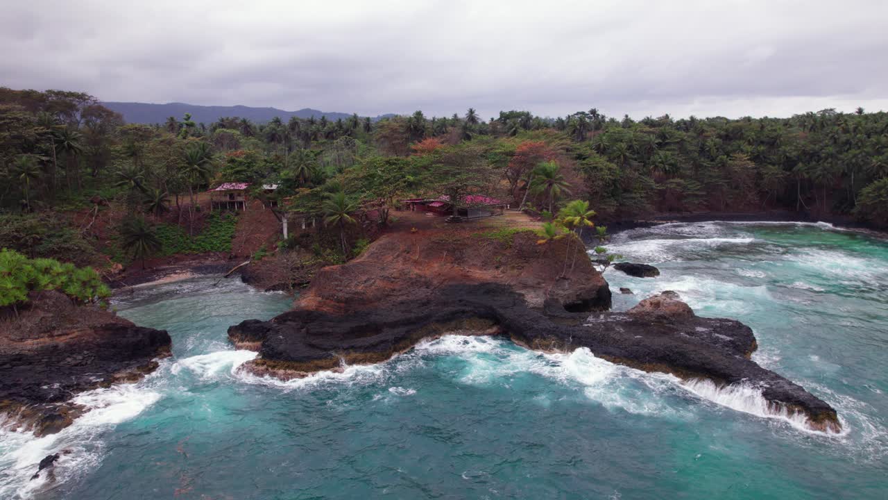Stormy waves crash on Praia Piscina, São Tomé, a dramatic blend of wild ocean power and serene tropical beach landscape