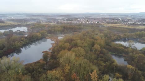 foggy dawn misty colourful nature reserve above autumn woodland landscape aerial dolly right