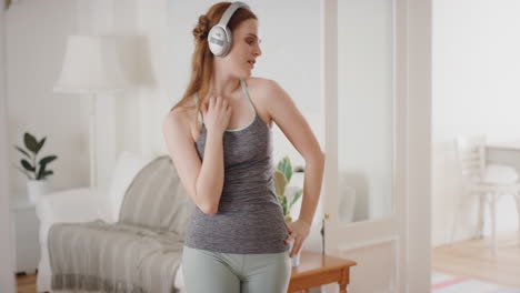 happy young woman dancing at home wearing headphones listening to music celebrating with funky dance moves enjoying freedom having fun on weekend 4k