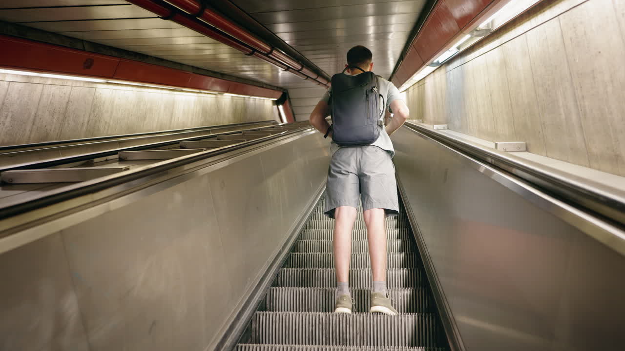 Man with Backpack on Subway Escalator