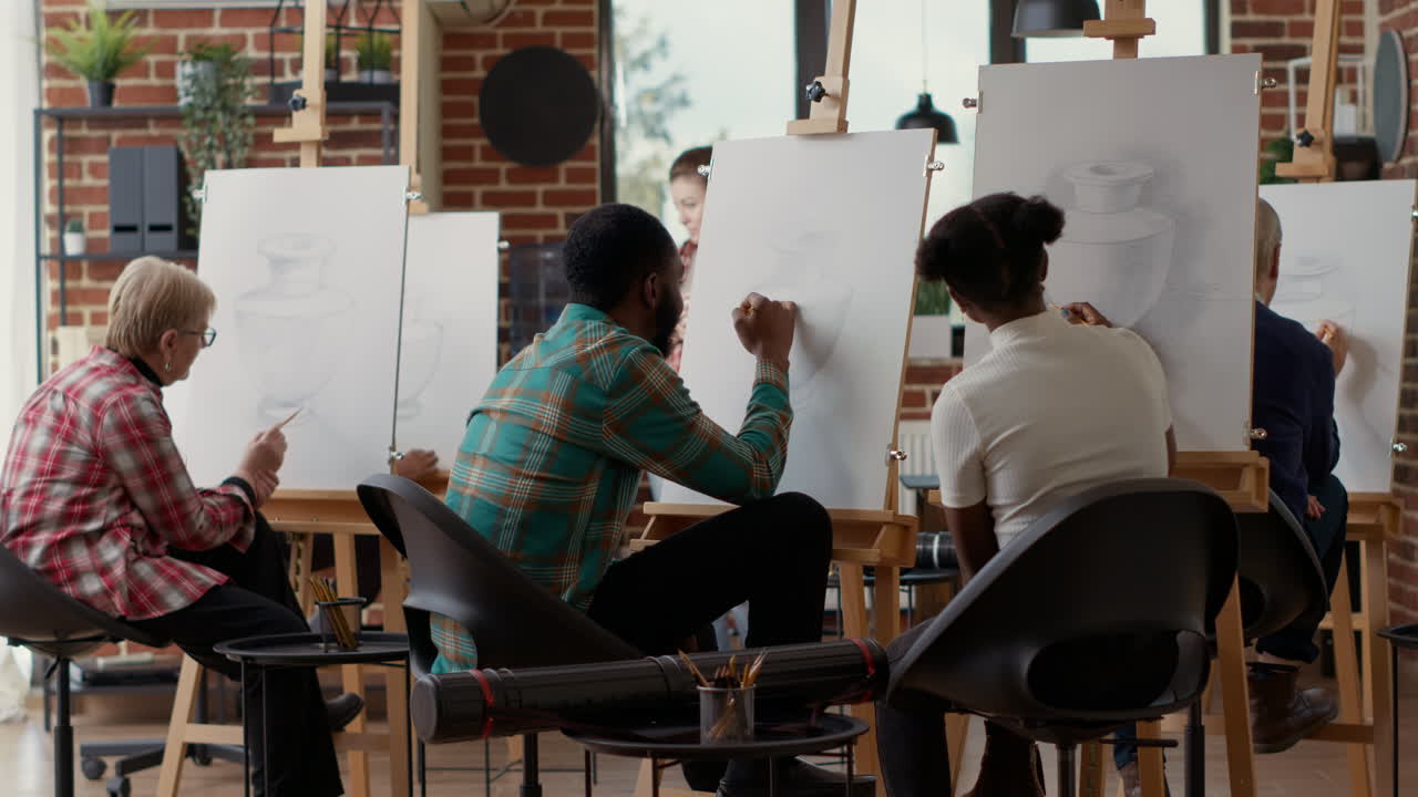 Young students drawing on canvas and talking about artwork