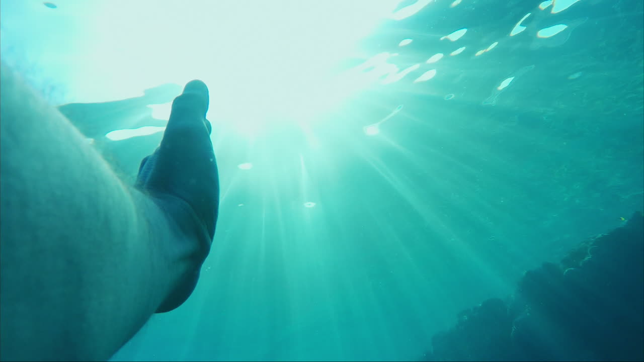la mano del hombre llega al sol bajo el agua