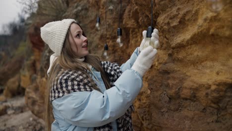 Woman Installing Outdoor String Lights on Rocks