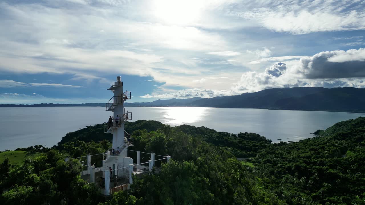 무성한 열대우림, 잔잔한 바닷물, 고대비 구름을 드러내는 하얀 등대에서 관광객들의 놀라운 공중 전망