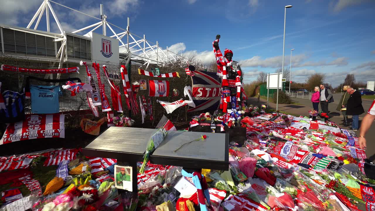 People pay their respects at the Gordon Banks statue by the Stoke City stadium, people signing shirts, scarves, flags and the book of remembrance
