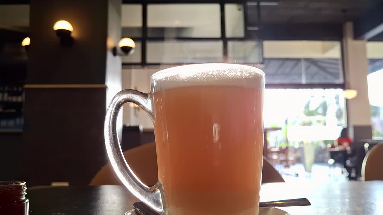 Enjoying a refreshing lemon ginger honey Steaming Hot Beverage at a cozy cafe on a sunny afternoon