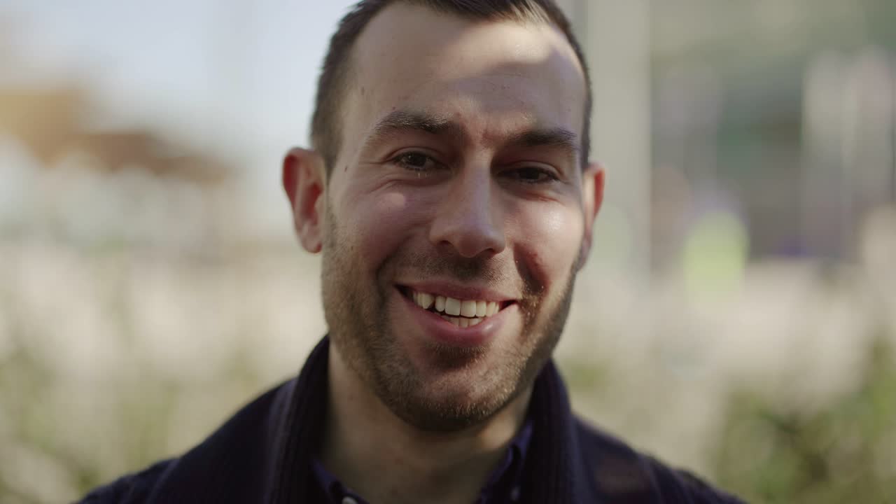 un joven bloguero guapo sonriente grabando un video