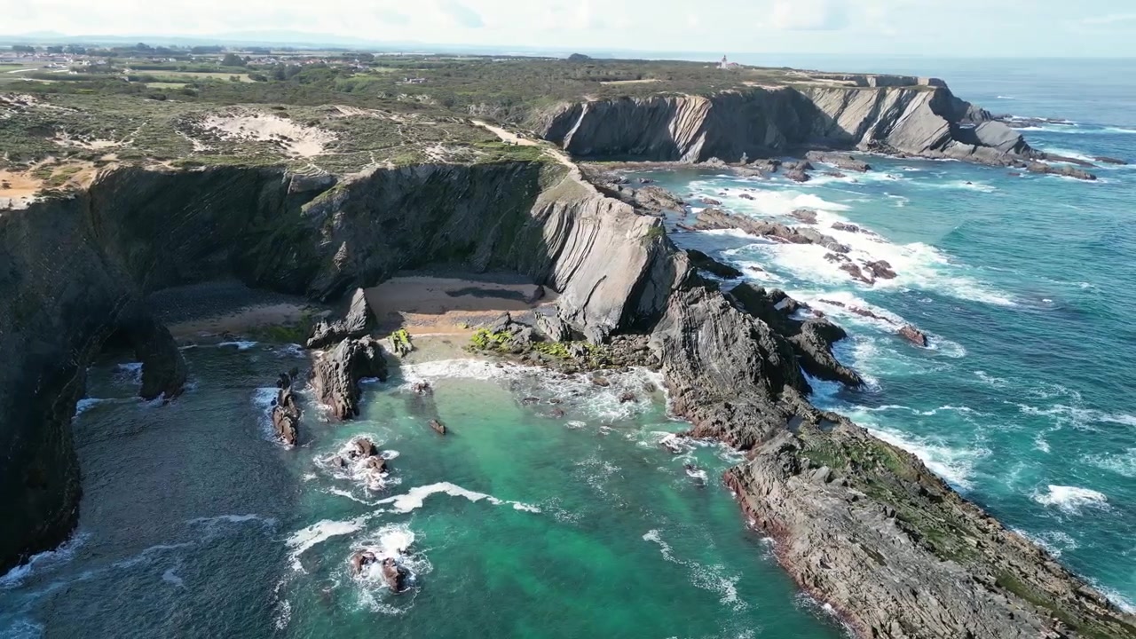 Riprese aeree con drone di Praia do Cavaleiro, Portogallo: aspre scogliere atlantiche, onde oceaniche e un paesaggio costiero drammatico sotto luce naturale. Ideale per progetti di viaggio e natura.