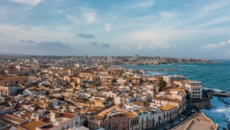 high amplitude aerial hyperlapse over ortigia island in sicily. medieval town by the mediterranean sea with historic buildings in italian landscape. unesco world heritage site.