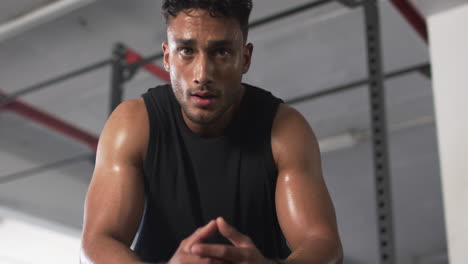 sweating and resting, man in gym taking break from workout