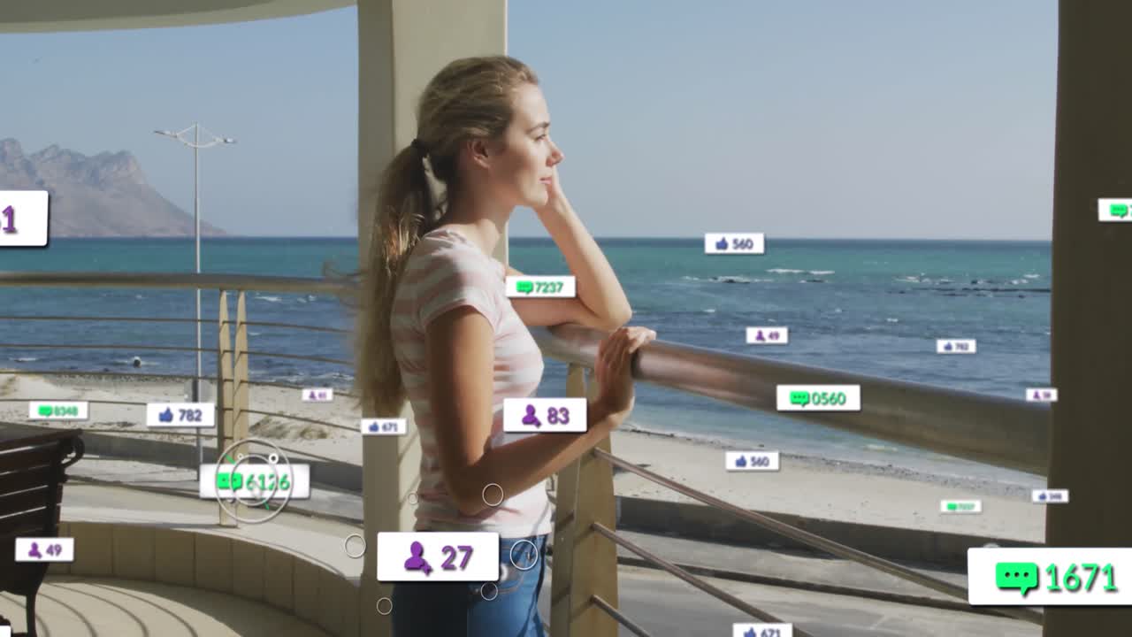 animación de iconos de las redes sociales en pancartas sobre una mujer caucásica relajada admirando la vista por la costa