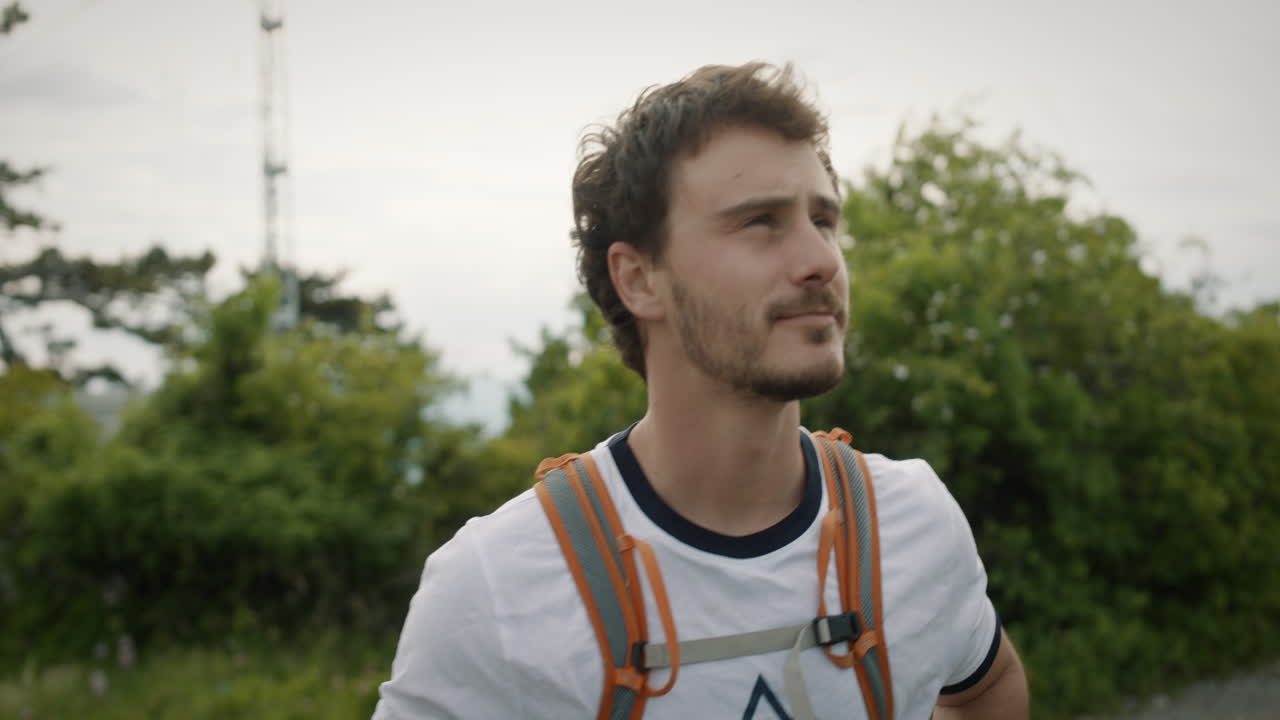 Turgåer går mot toppen av fjellet Trstelj i Slovenia, rundt ham er det noen trær og busker.