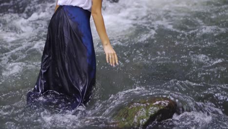 a girl touches the water in the river in the salto encantado park located in misiones, argentina