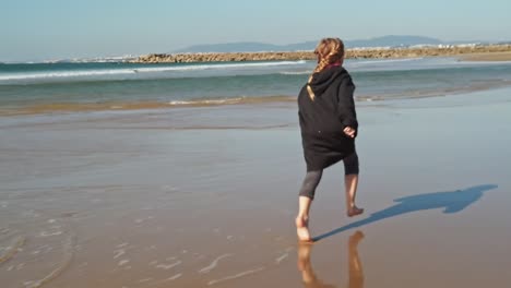 young girl running sand beach, enjoying holiday or vacation, golden hour view