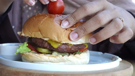 una mujer comiendo una deliciosa hamburguesa.