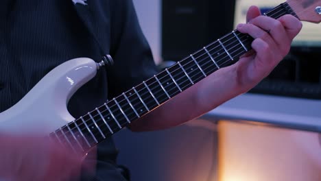 a mature man playing guitar in the studio