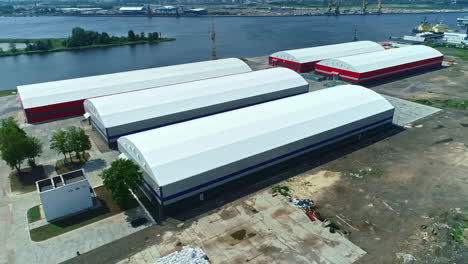 aerial view around warehouse halls at a industrial port at the sea, sunny day