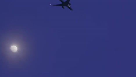 airplane flying by the moon during dusk