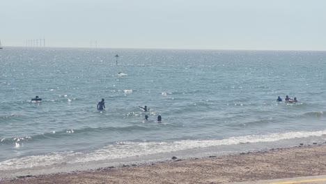 gente disfrutando del clima soleado en la playa en clacton on sea, essex, reino unido