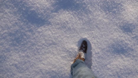 pov boots walking through thick fresh powdery snow in slow motion on a sunny winter day in bavaria, germany