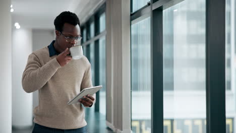 man drinking coffee and using tablet in office