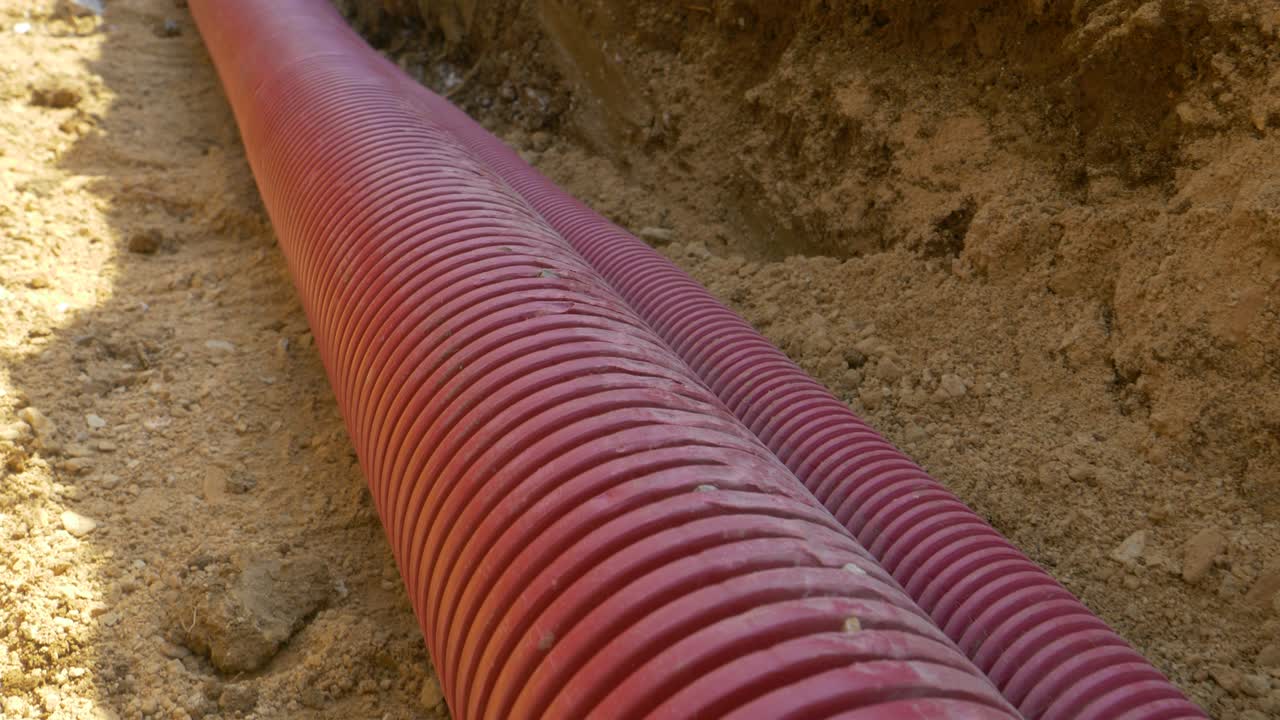 CLOSE UP: Detailed shot of corrugated plastic telecommunication tubing in ditch