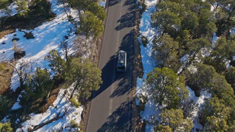 Following-A-Car-Driving-On-Road-Passing-Through-Snow-Forest-Near-Grand-Canyon-National-Park-In-Arizona,-USA