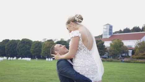 el novio levanta y gira a la novia felizmente.