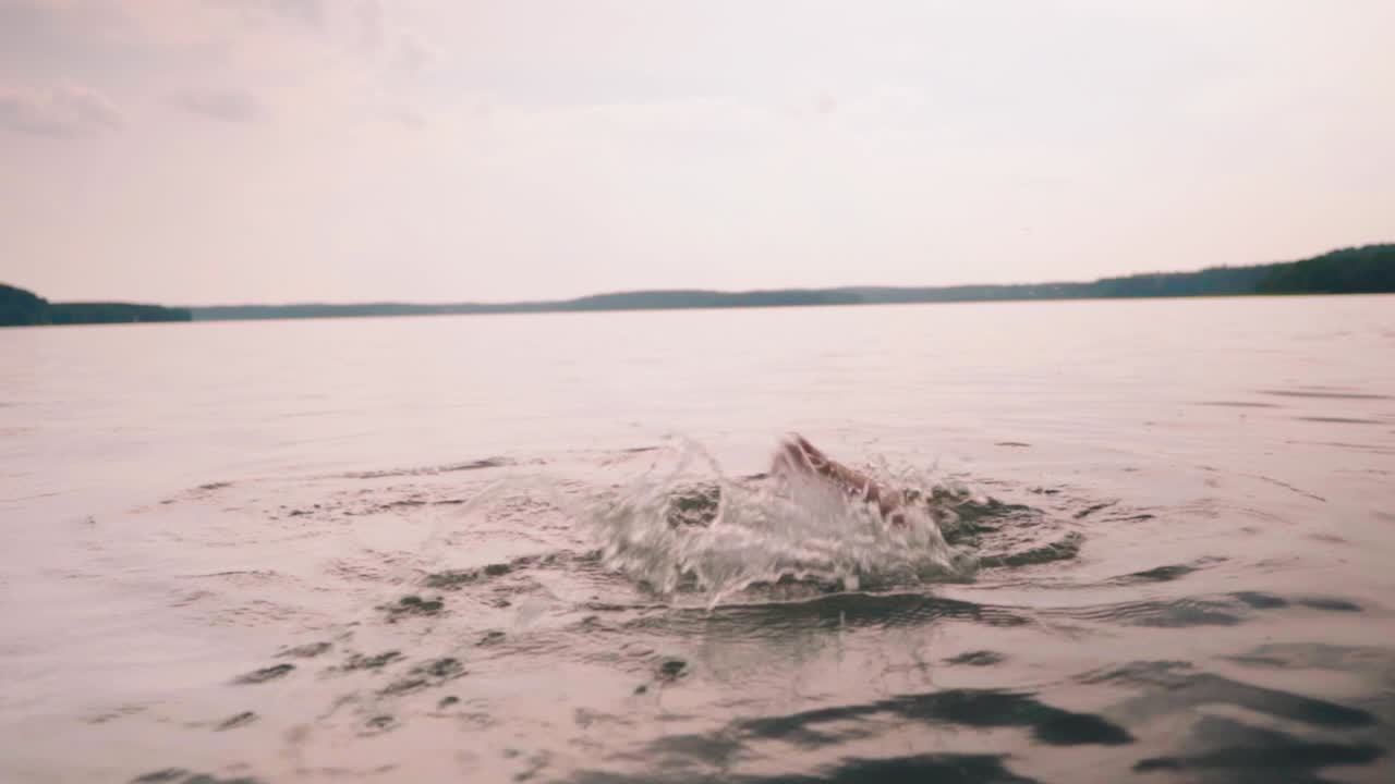 un niño lindo con gafas de natación nadando en el lago, concepto de infancia feliz