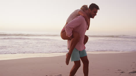 una pareja caucásica disfrutando del tiempo en la playa.