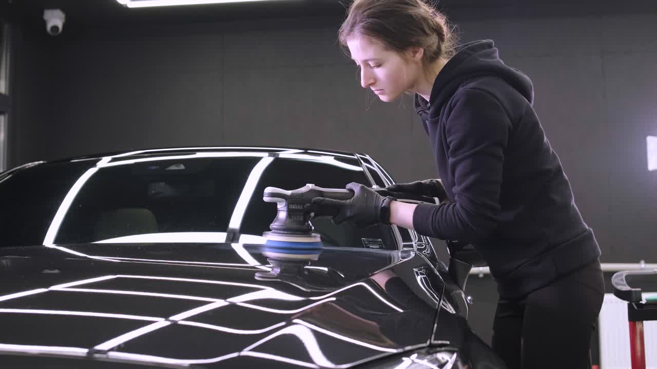 페인트 복원을 위해 기계와 폴리셔를 사용하는 전문 자동차 디테일링.