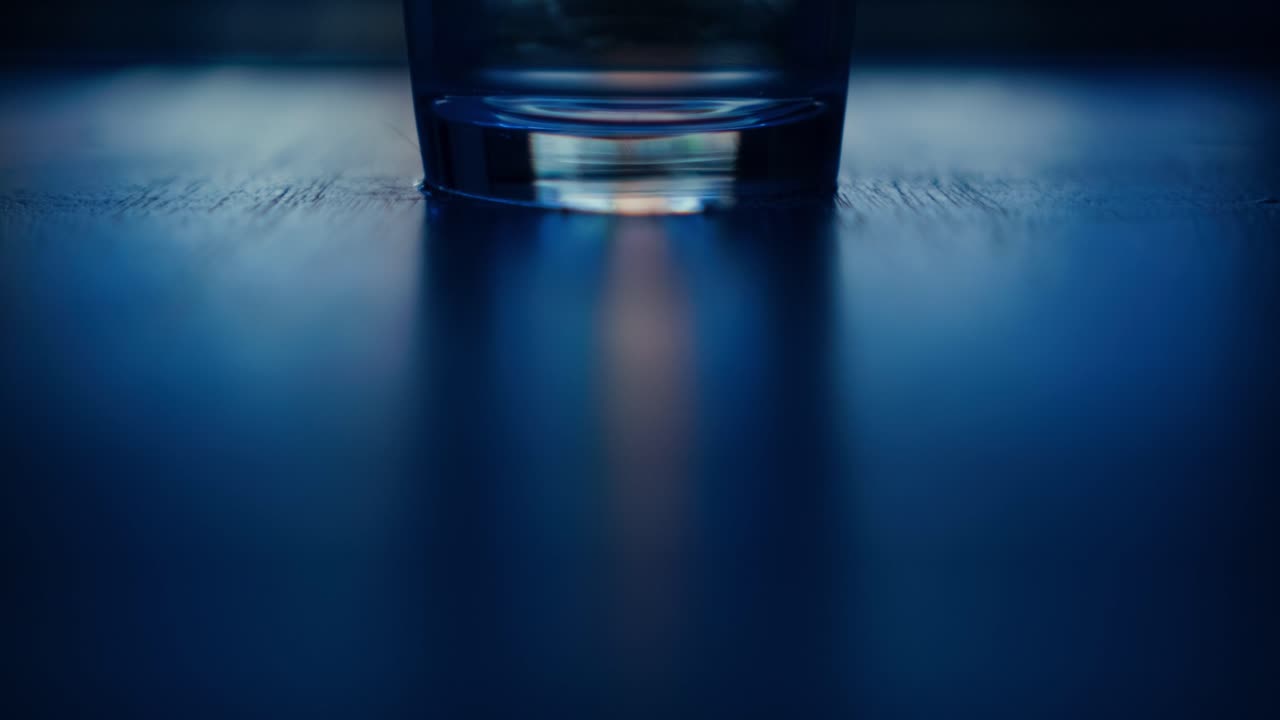 кинематографический статический средний кадр дна прозрачного стакана воды перед t