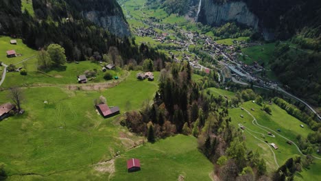 drone shot revealing lauterbrunnen valley and staubbach waterfall with the snow capped mountain in the background from wengen village