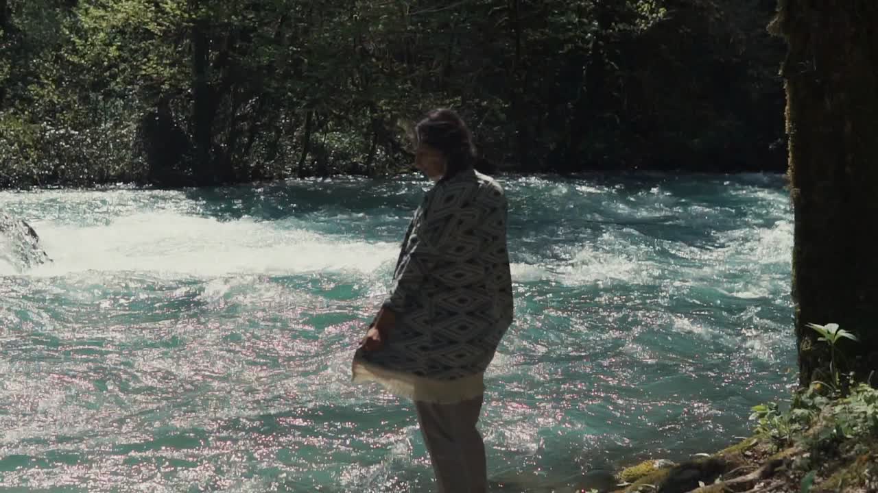por un río en un bosque mujer