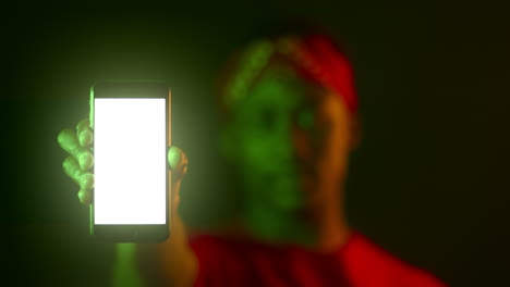 person holding a smartphone with a blank screen under green lighting