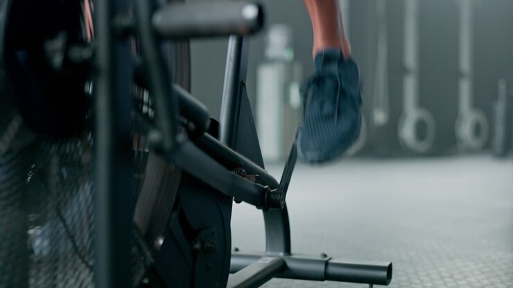 Fitness, legs and feet in cycling at gym