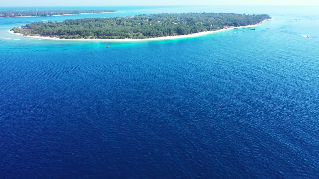 인도네시아 길리에 있는 깊고 푸른 바다로 둘러싸인 아름다운 원 모양의 무성한 초목과 하얀 모래 해변이 있는 열대 섬