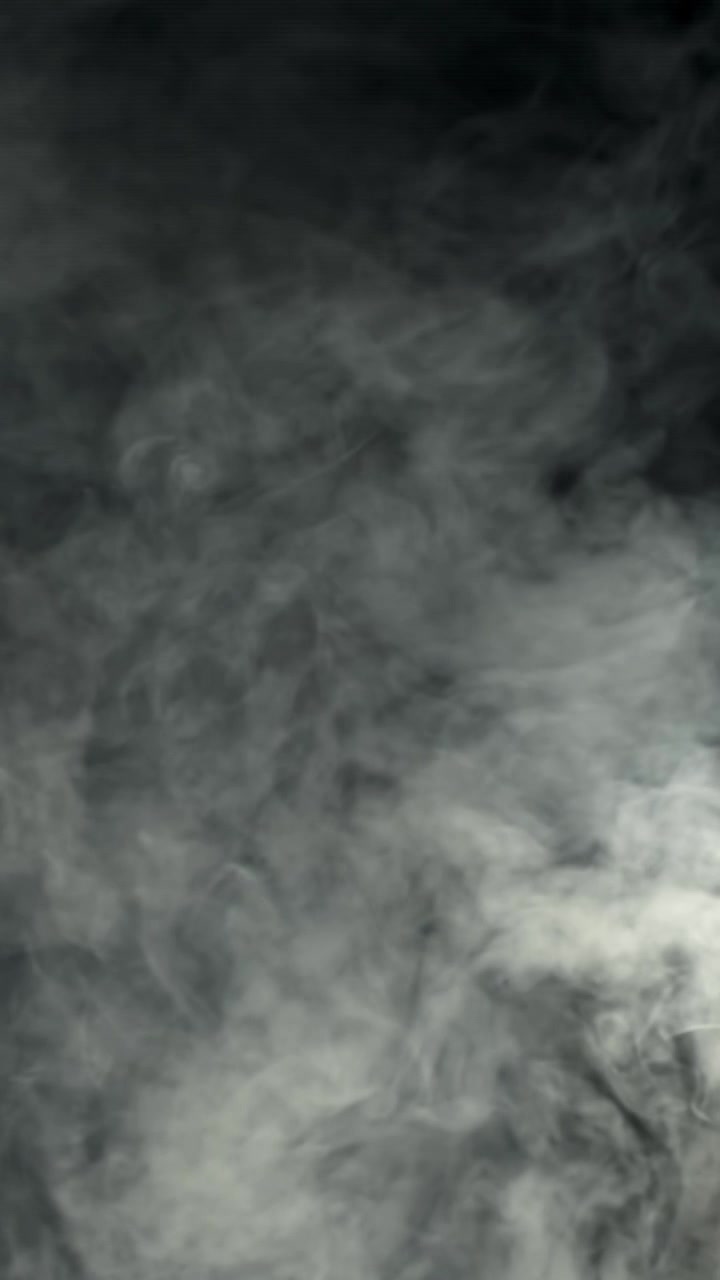 Fumo bianco denso che sale e si diffonde su uno sfondo scuro