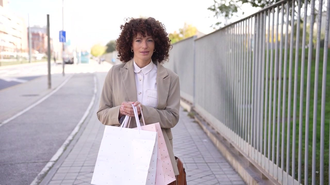 Una donna alla moda, vestita con un outfit casual ma elegante, passeggia in un ambiente urbano