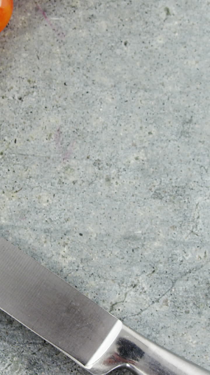 Cherry tomatoes and kitchen knife on concrete