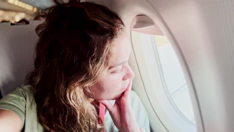 pensive female traveler watching the view from a flight