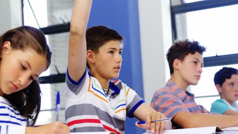 estudiante levantando la mano en el aula