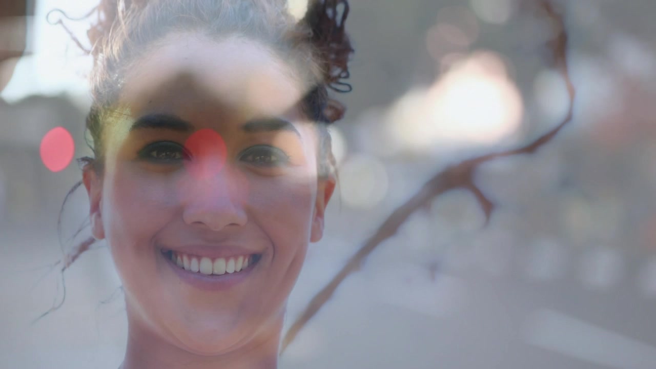 Donna che avanza, la telecamera si allontana, rivelando un sorriso con rami in sovrapposizione e bokeh per uso editoriale.