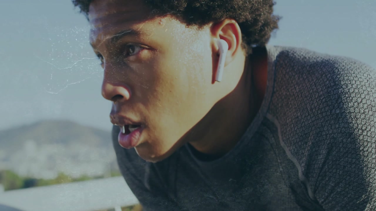 Wearing wireless earbud male athlete catching breath on track, displaying animated health chart